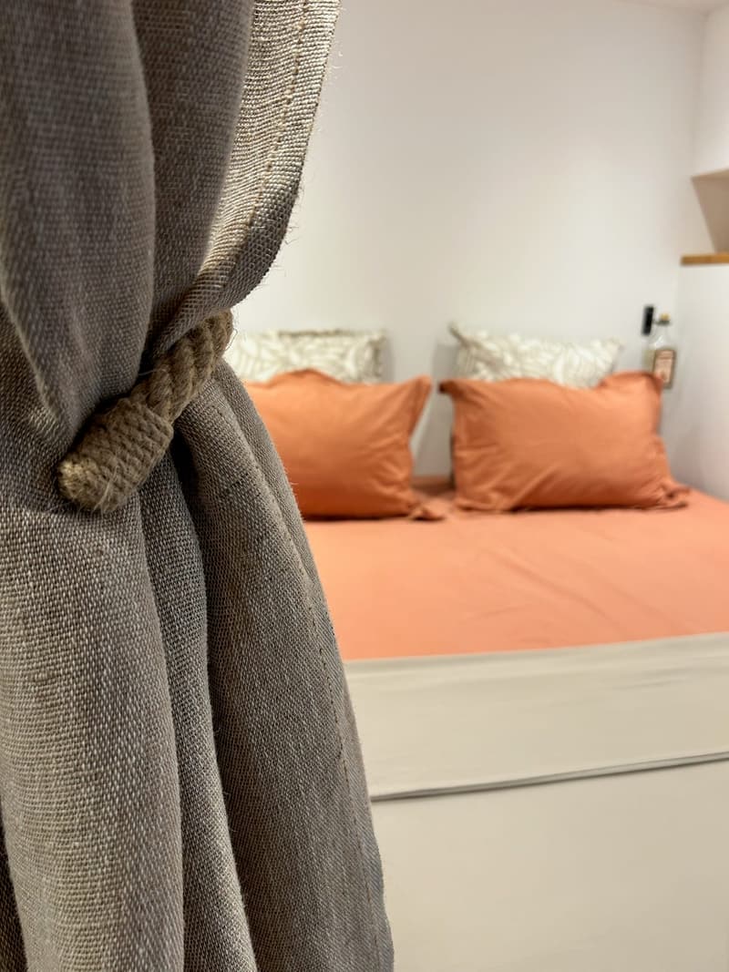La chambre vue derrière le rideau retenu par une embrasse
