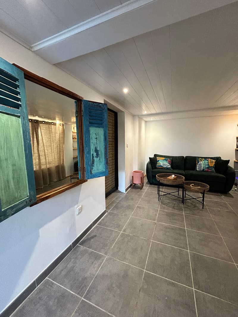 Le séjour vu depuis l'entrée, persiennes turquoise ouvertes