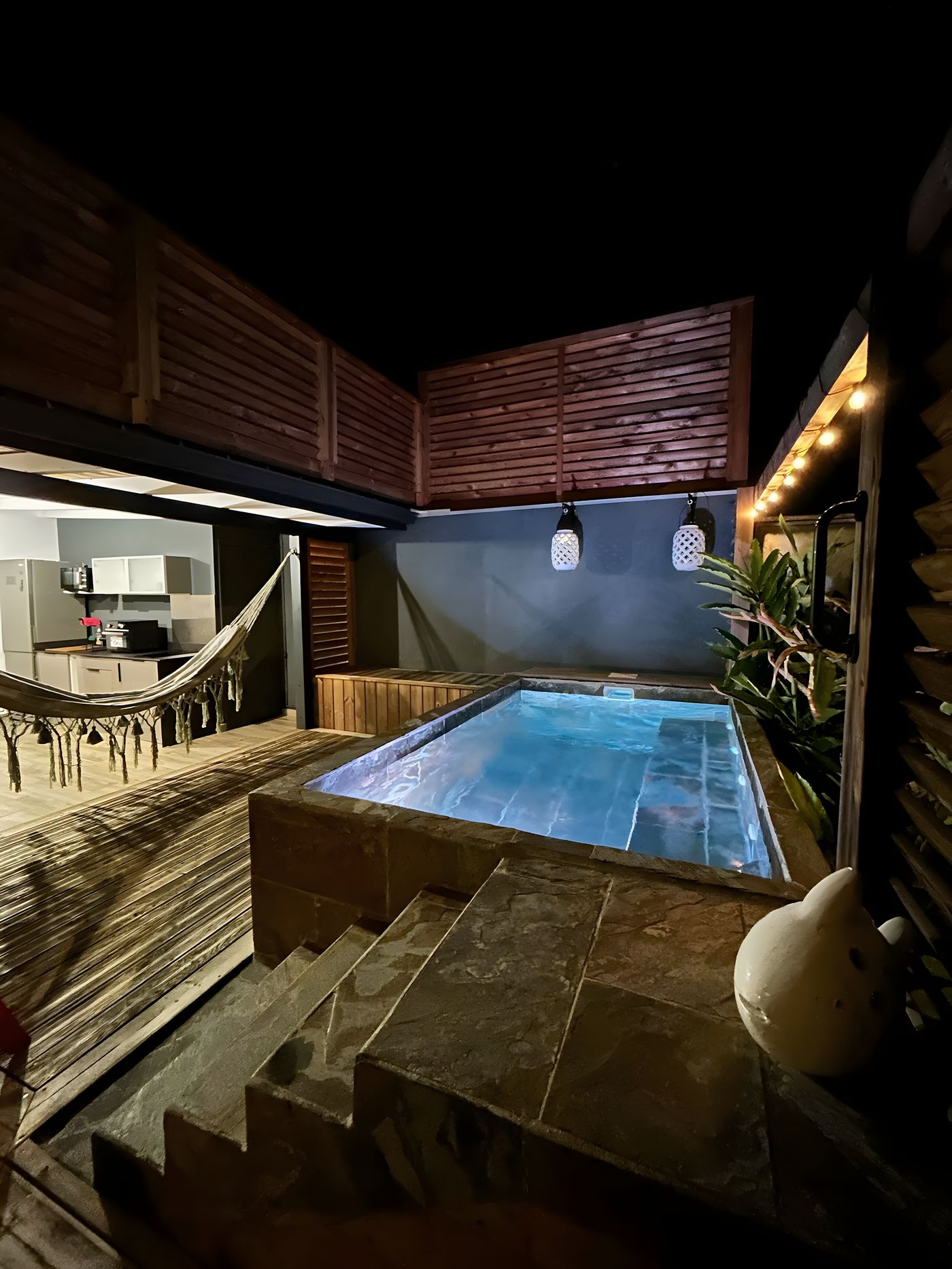 The plunge pool lit up at night, at the end of the deck