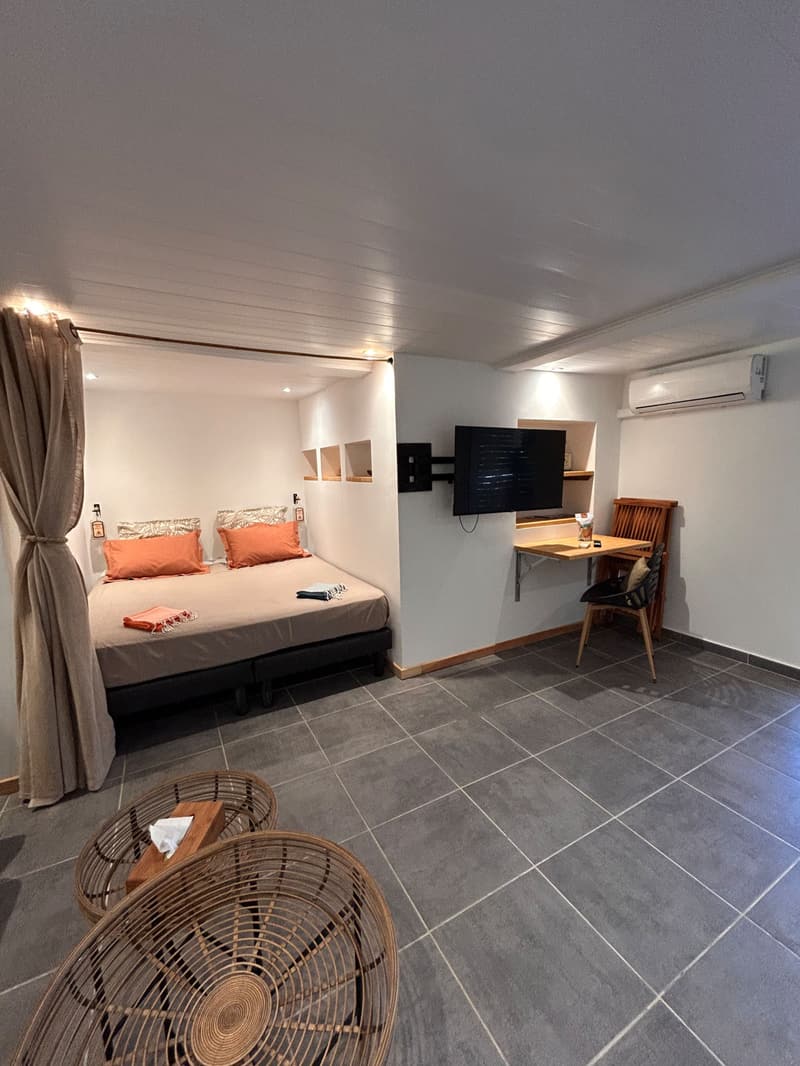 The bedroom and its desk corner, wall-mounted TV and air conditioning