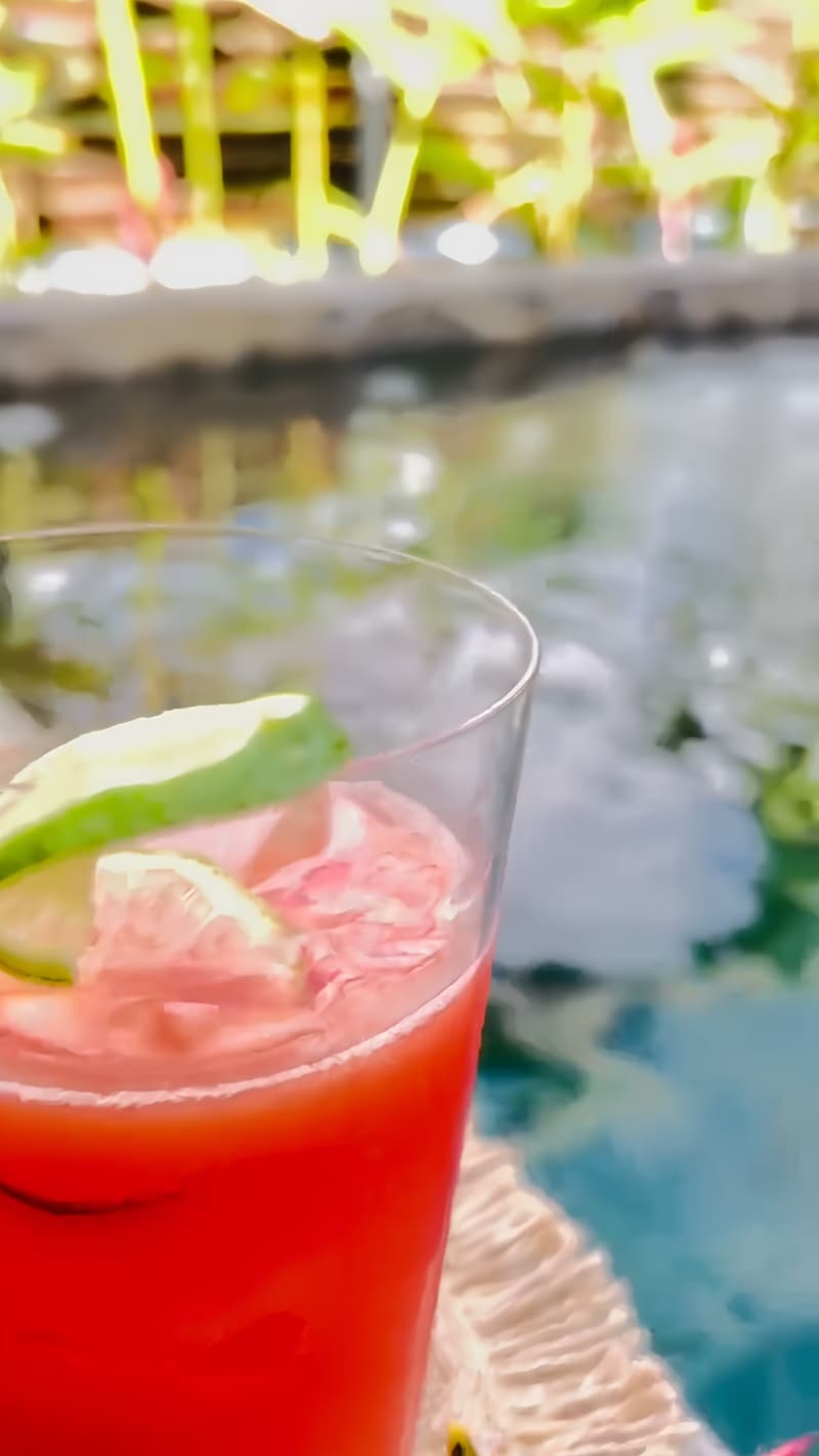 A red cocktail set on the edge of the plunge pool