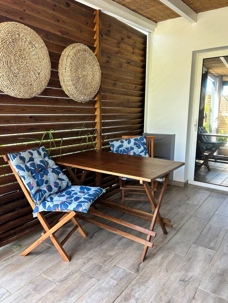 The terrace dining corner, two folding chairs and a wooden table