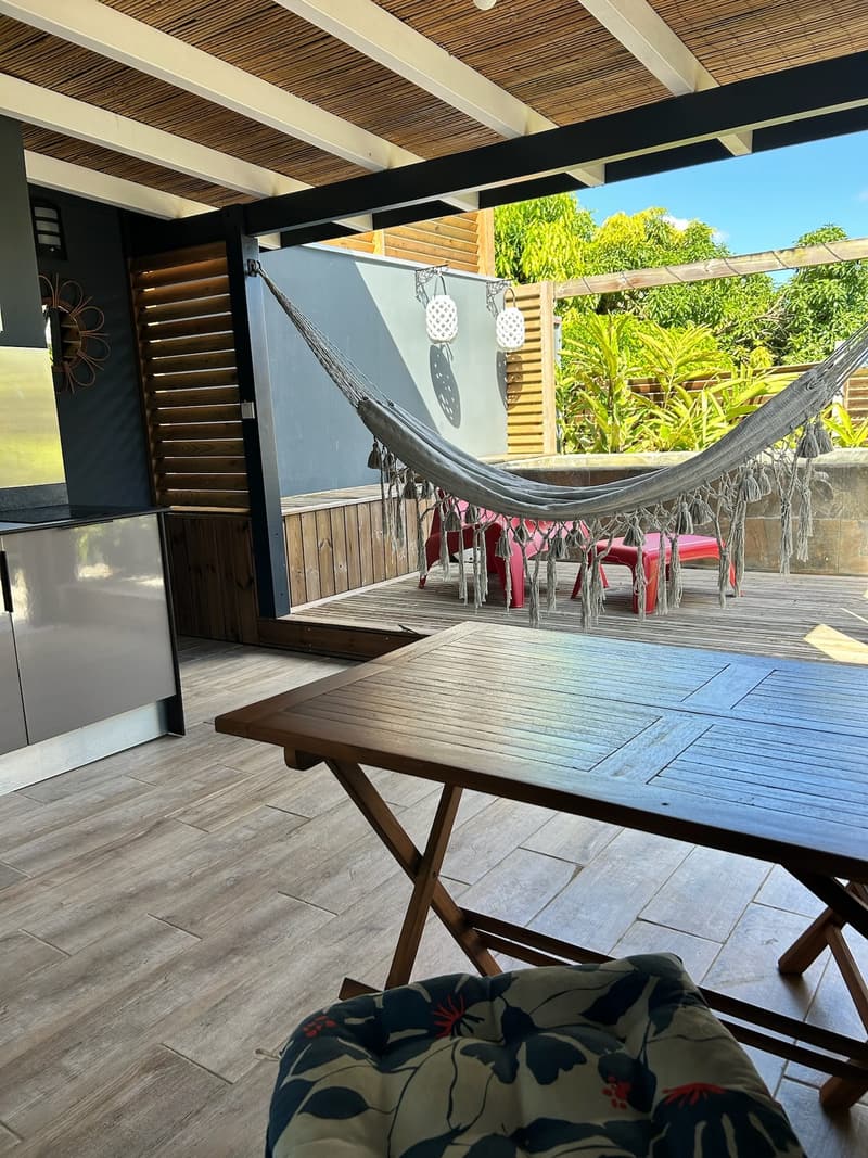The wooden terrace table, the hammock behind