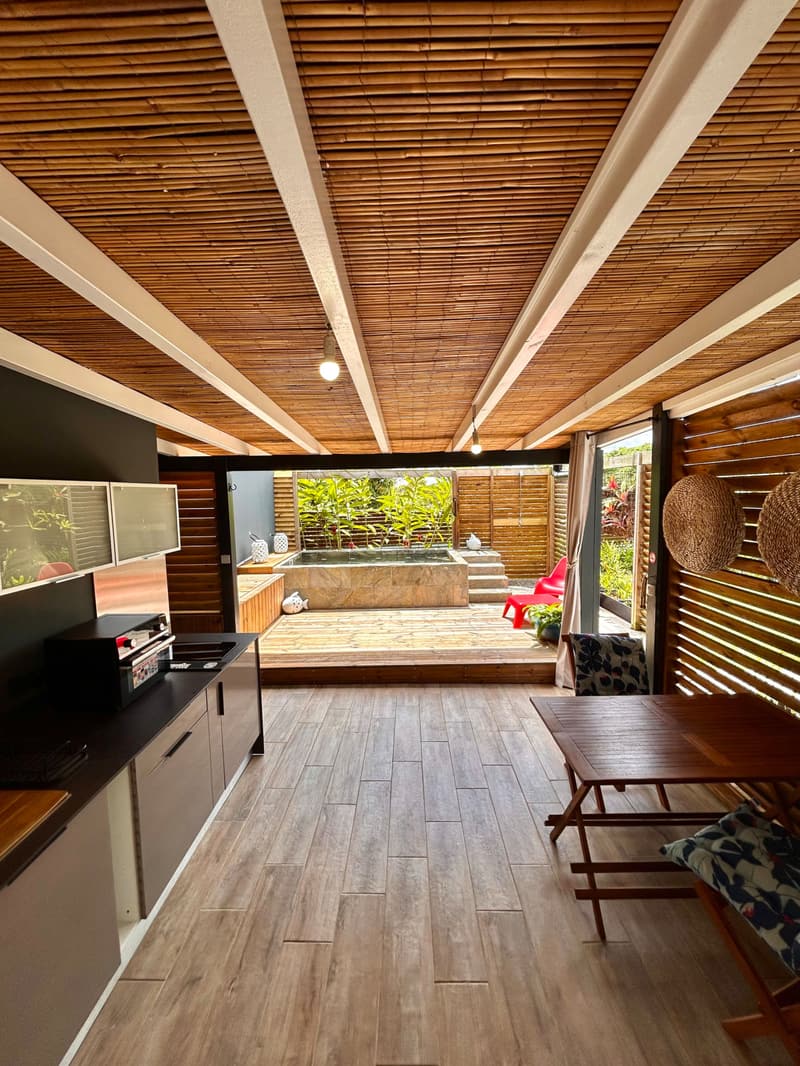The terrace under its bamboo ceiling, the outdoor kitchen and the pool at the back